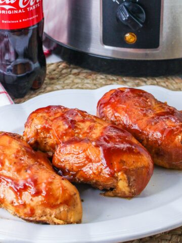 Barbecue Chicken served on a white platter with Coca Cola and a slow cooker in the background