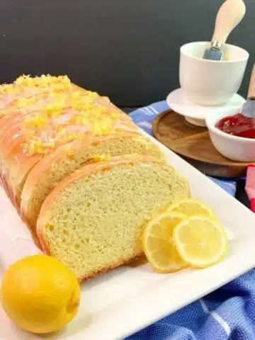Lemon Easter Bread on white plate with fresh lemons.