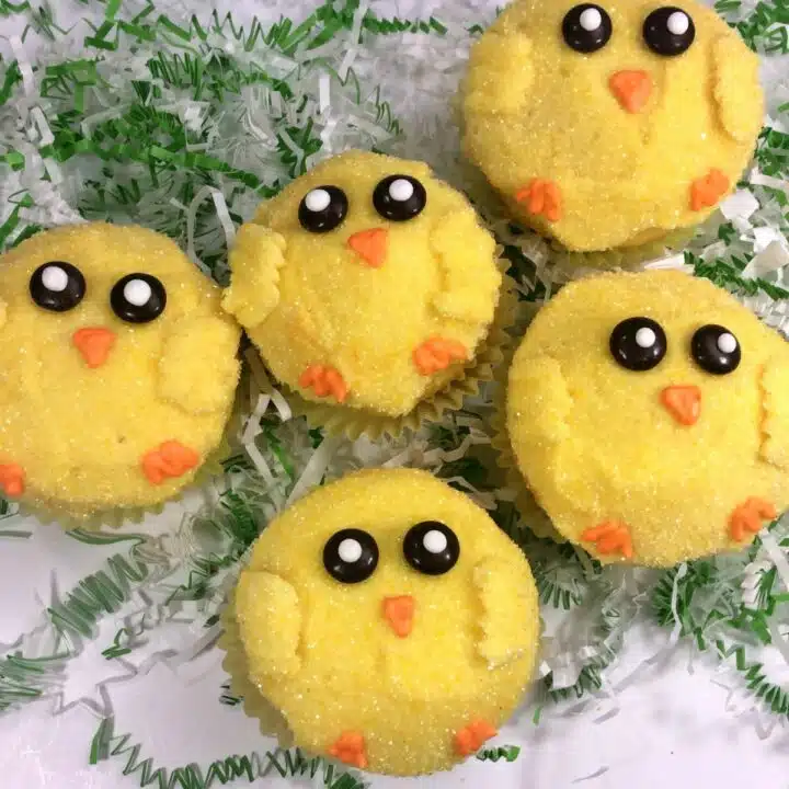 cupcakes decorated as Easter chicks on white platter.