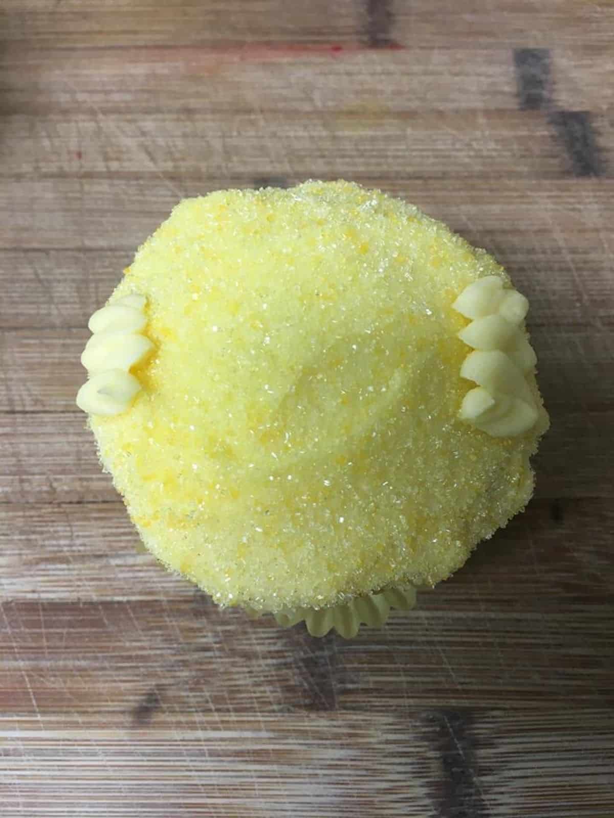 yellow cupcake with yellow decorating glitter.