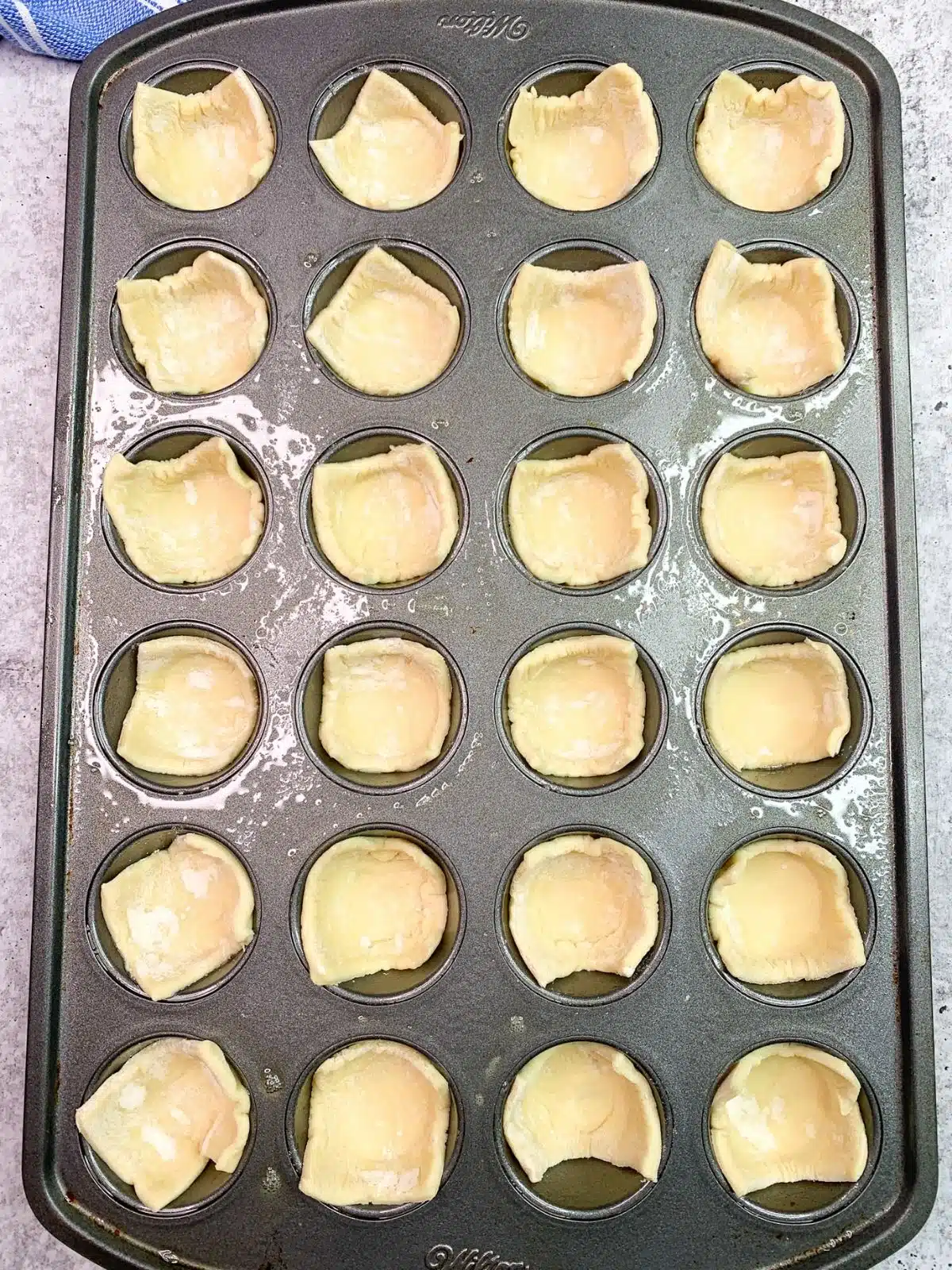 add puff pastry squares to muffin pan
