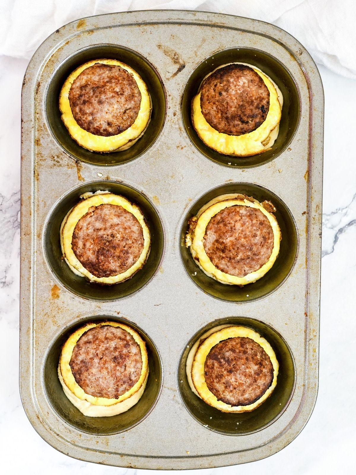 Add sausage to the top of cooked eggs.