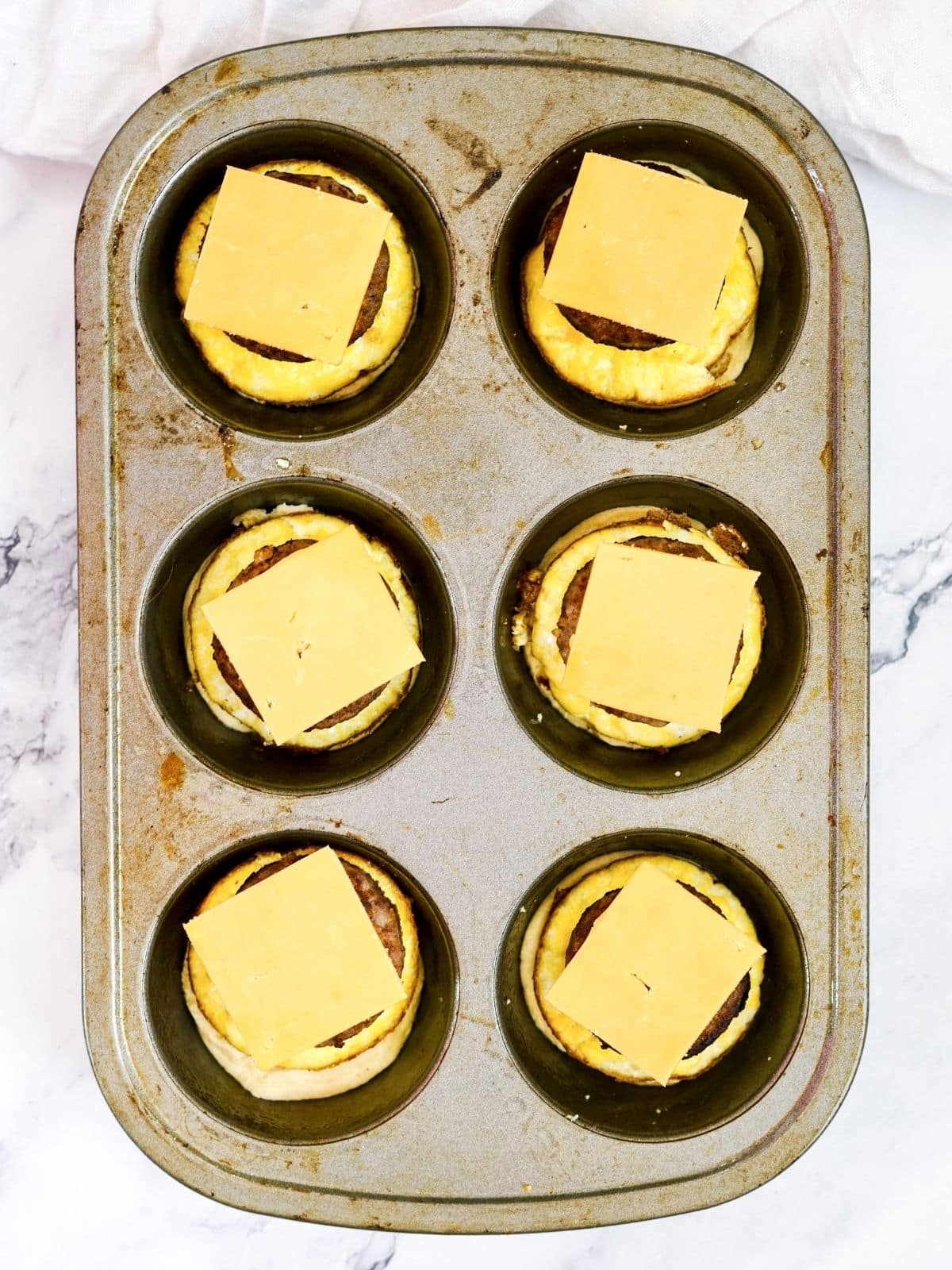 Add cheese to the top of eggs, biscuit and sasauge patty.
