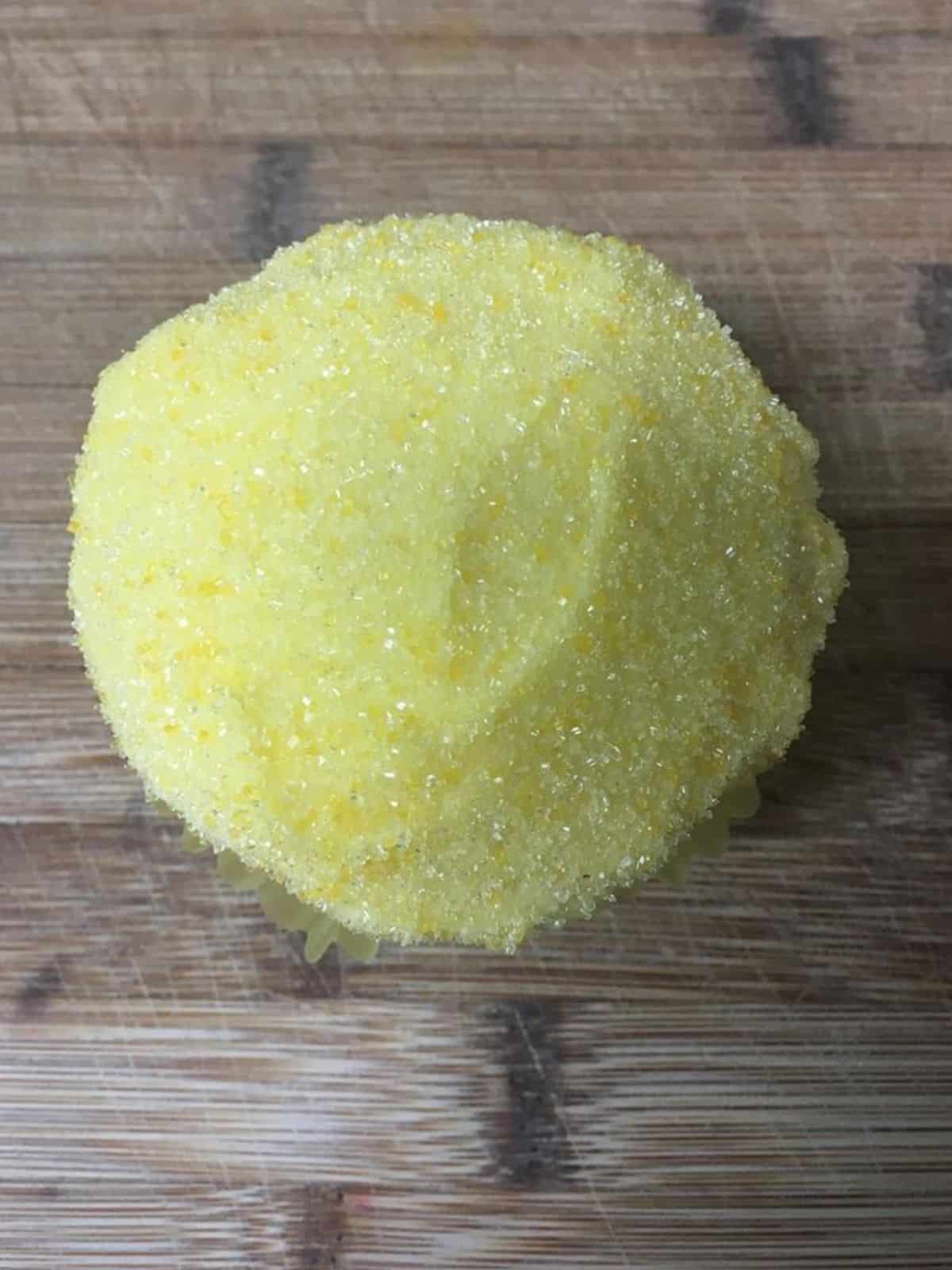 cupcake decorated with yellow sanding sugar.
