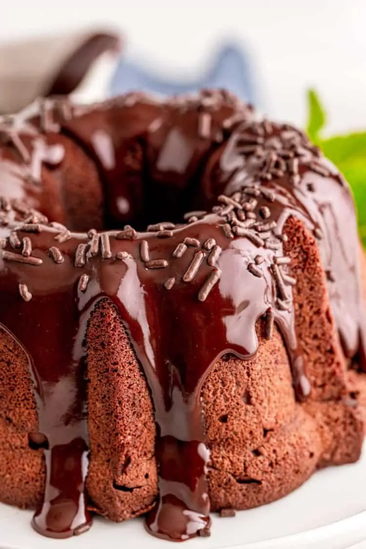 Mini chocolate bundt cake with chocolate glaze pouring down sides.