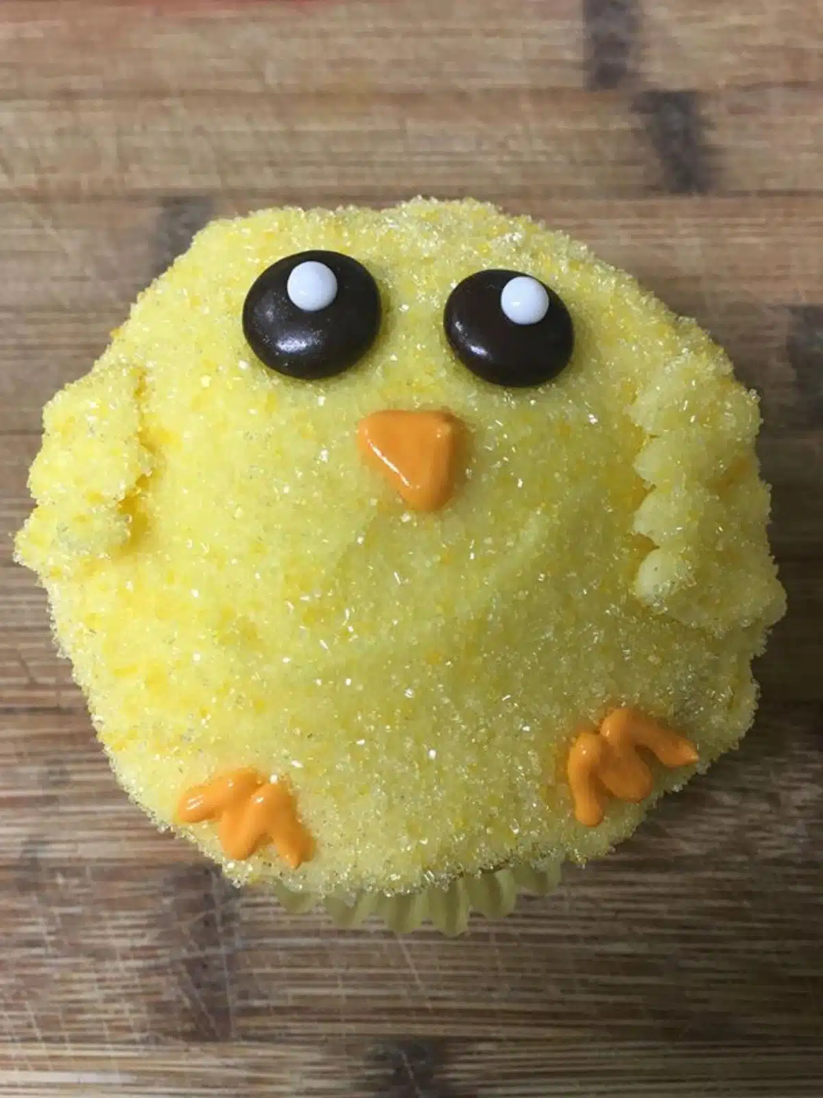 chick cupcake decorated with eyes, beaks and feet.