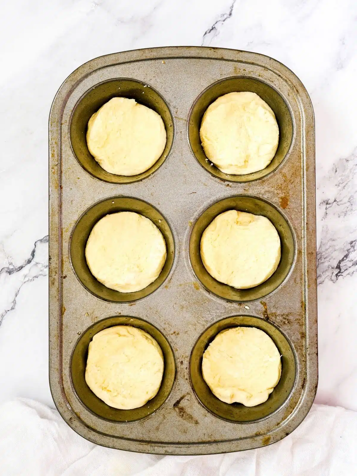 uncooked biscuit in muffin pan.