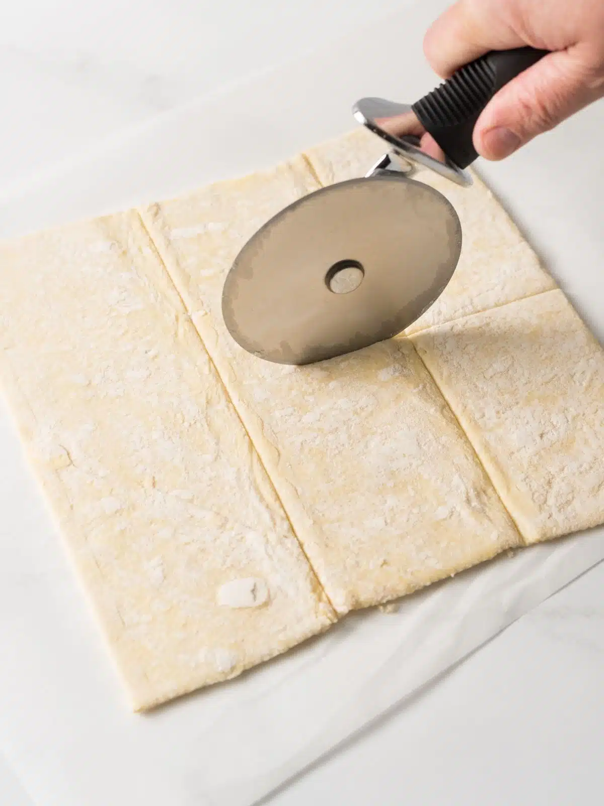 Cutting the puff pastry into 6 pieces with a pizza cutter