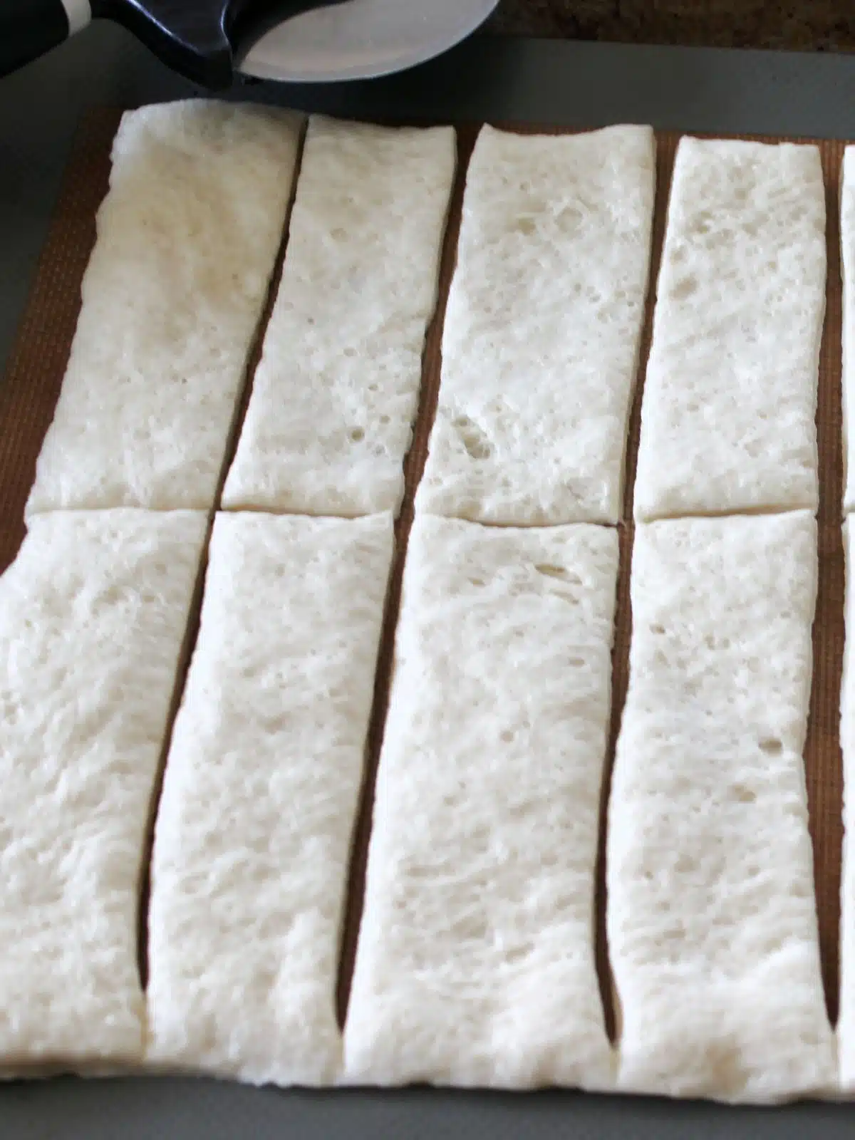 Pizza dough sliced into strips.