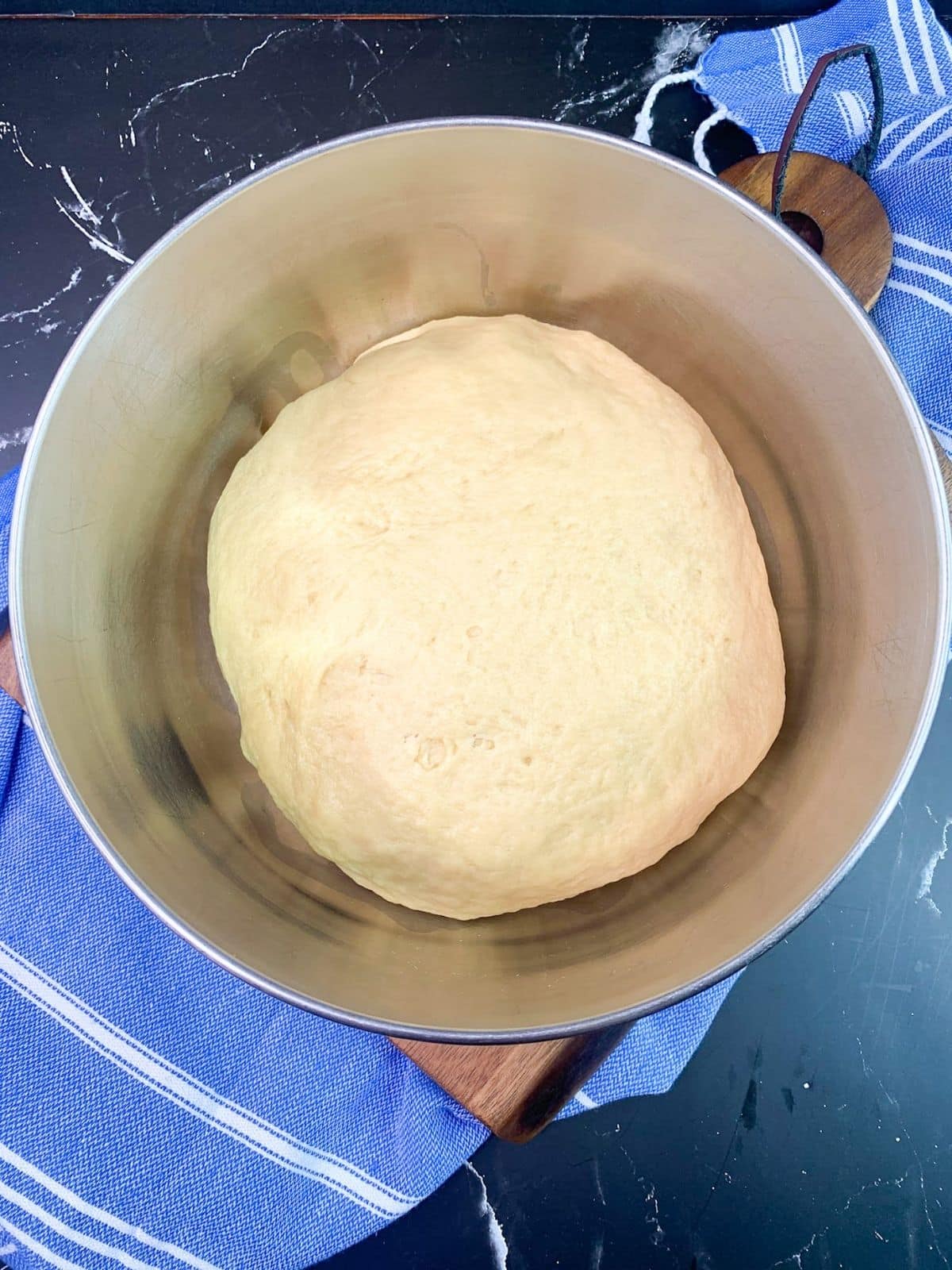 kneaded bread dough in mixing bowl.