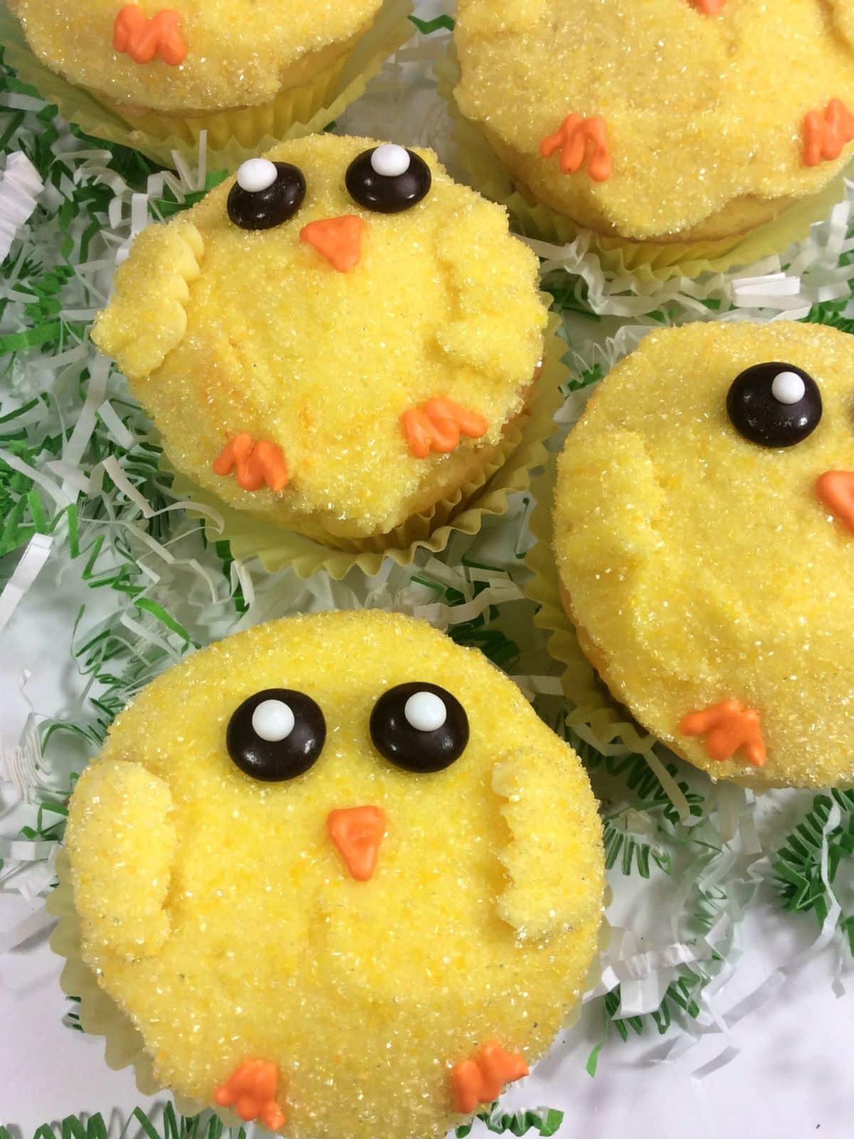 chick cupcakes decorated and on white platter ready to serve.