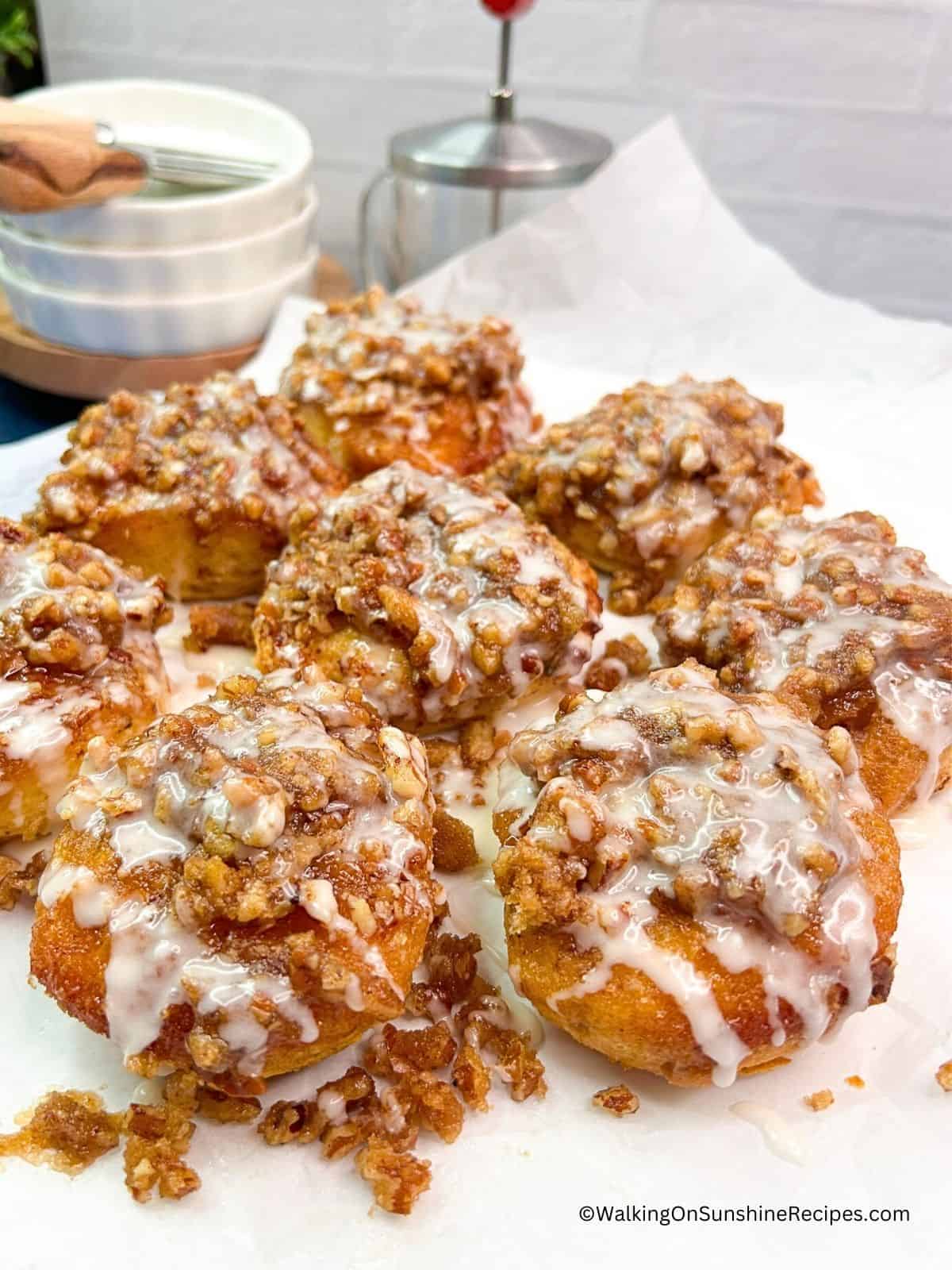 Pecan Rolls from Canned Cinnamon Rolls on white plate with powdered sugar glaze.