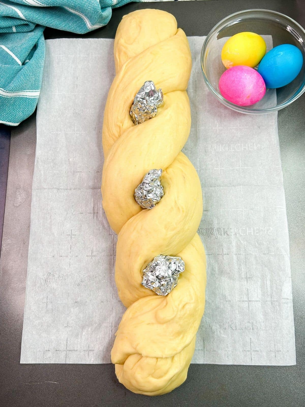raw dough braid with aluminum foil eggs as place holders.