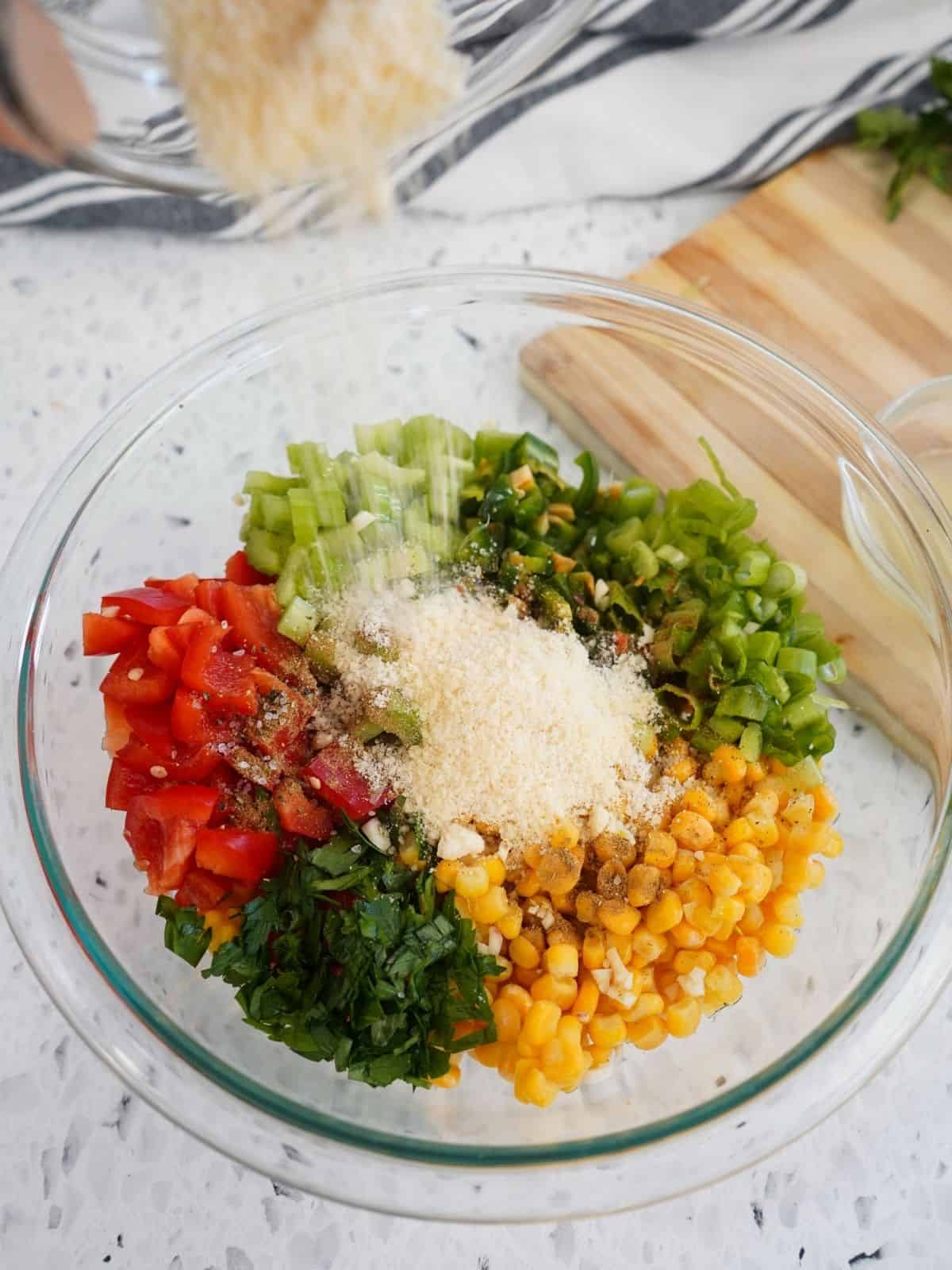 Add Parmesan cheese to bowl of salad ingredients.