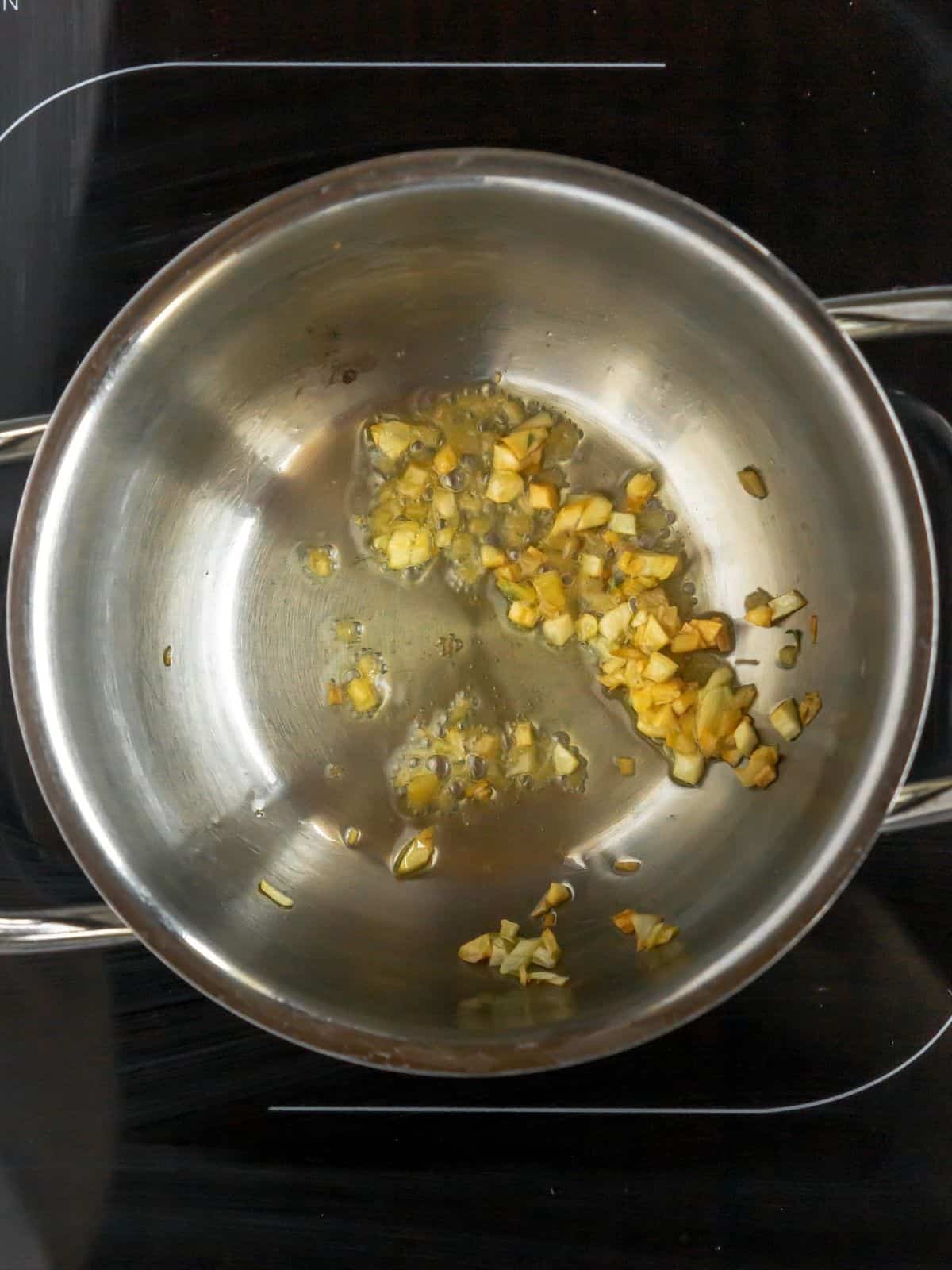 garlic and ginger cooking in frying pan.