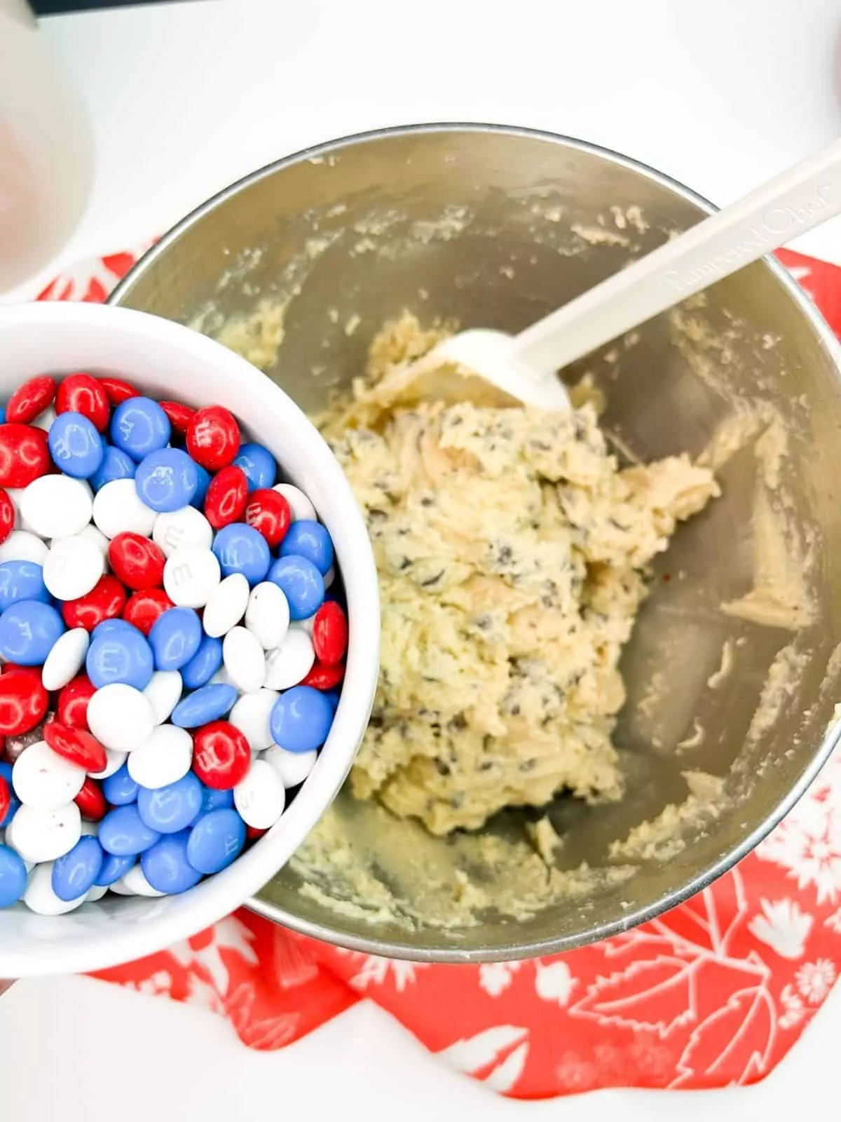 Adding red, white and blue m&ms to cookie dough.