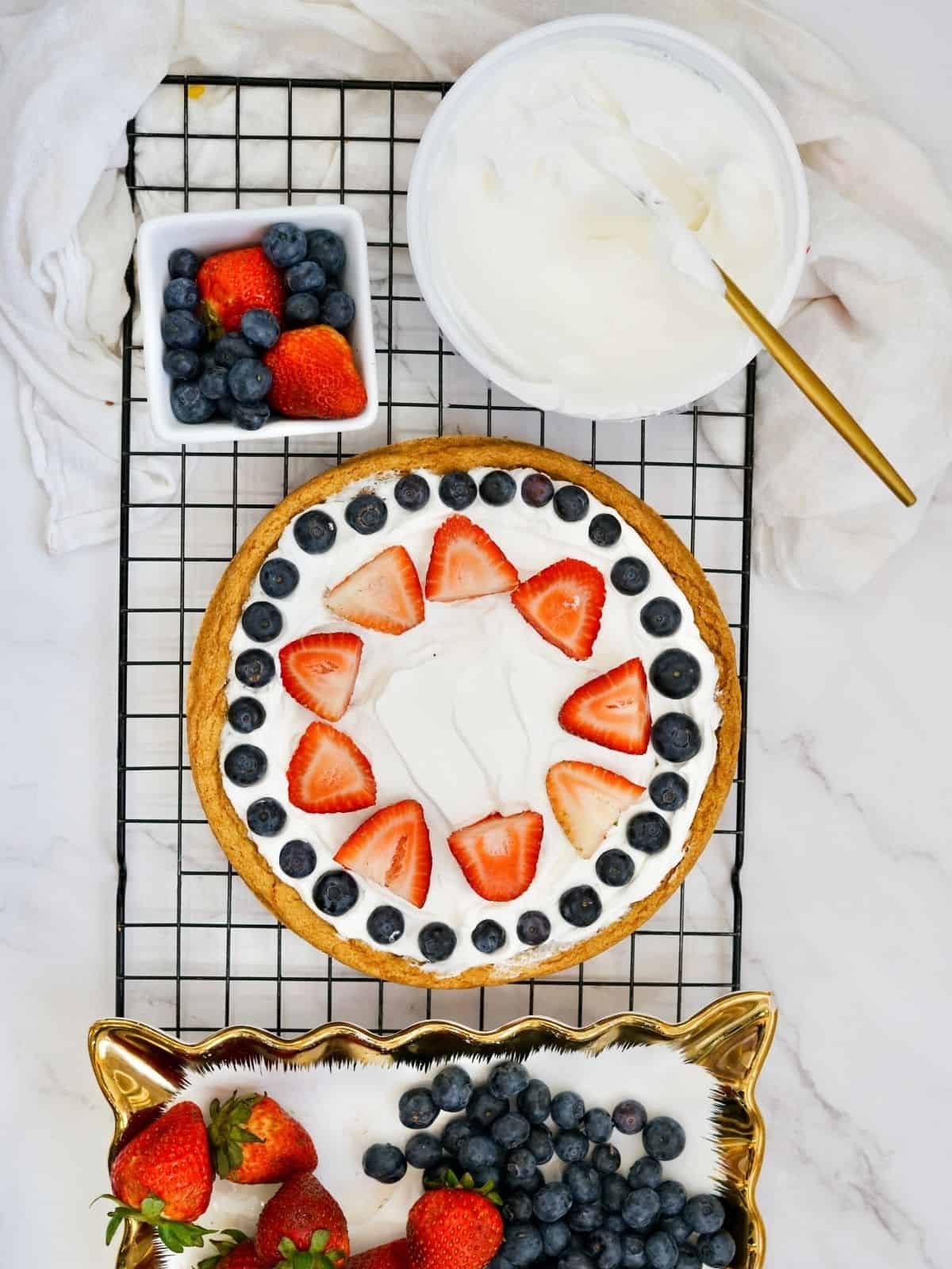 pizza made with sugar cookie dough and topped with Cool Whip and fruit.