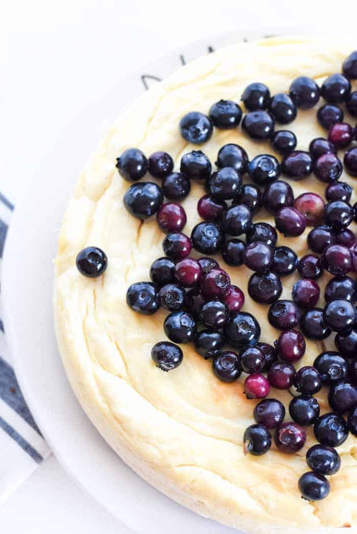 round cheesecake with blueberries on top.