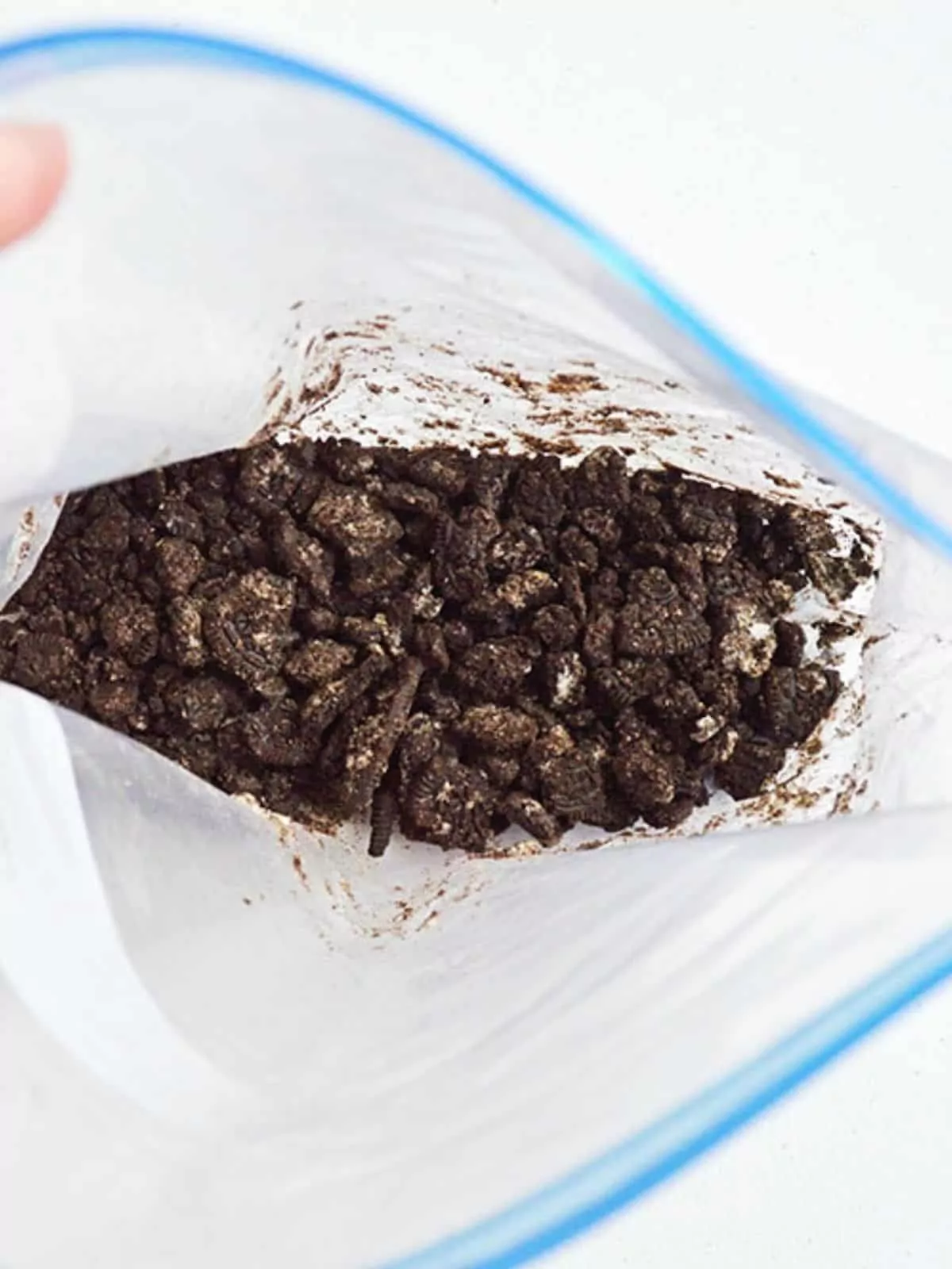 Crushed Oreo cookies in plastic food storage bag.