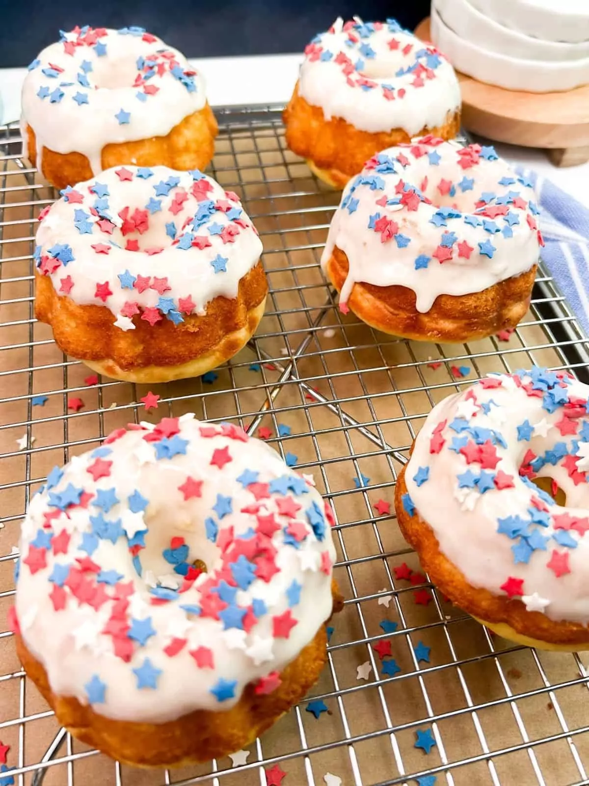 decorated patriotic bundt cake with frosting and star shaped sprinkles.