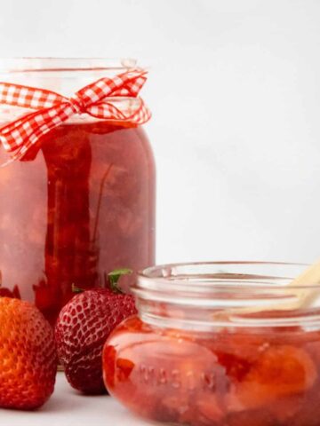 Whole strawberry sauce and jam in mason jars.