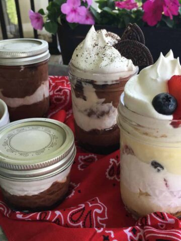 Chocolate and vanilla pudding in mason jars on tray.
