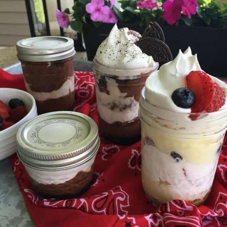 Chocolate and vanilla pudding in mason jars on tray.