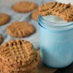 glass of milk in blue mason jar with peanut butter cookies.