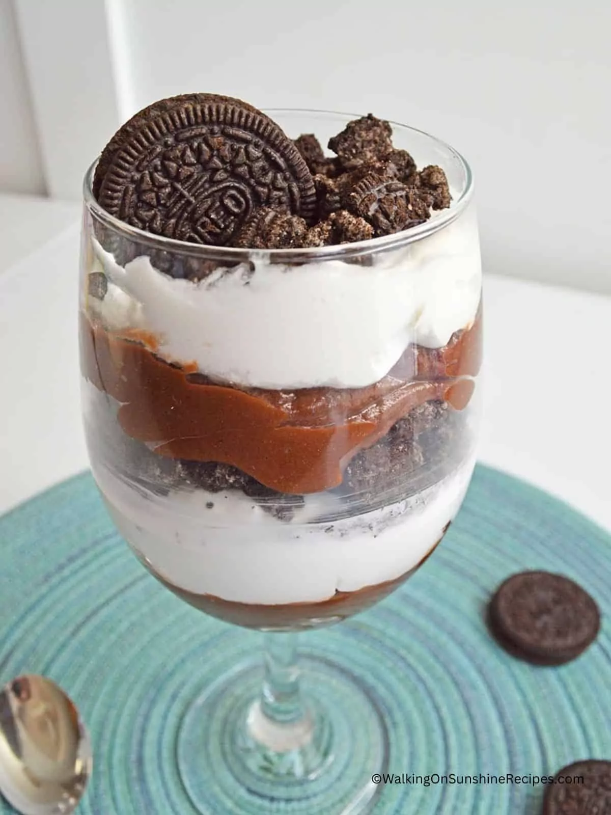 Completed photo of chocolate pudding parfait with whipped cream and Oreo cookies.