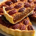 Homemade pecan pie with one slice on serving spatula.