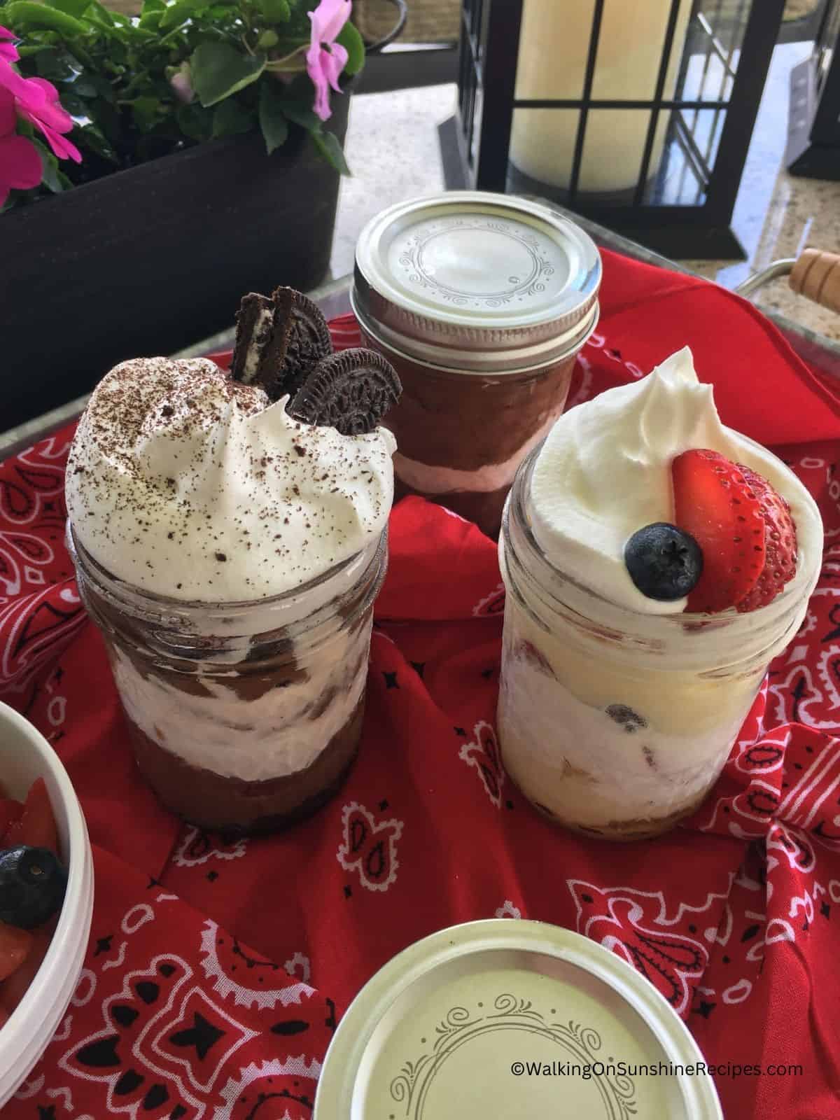 chocolate pudding with whipped cream in mason jar, vanilla pudding with whipped cream.