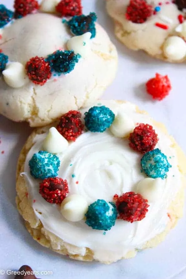 sugar cookies with frosting and red, white and blue colored chocolate chips.