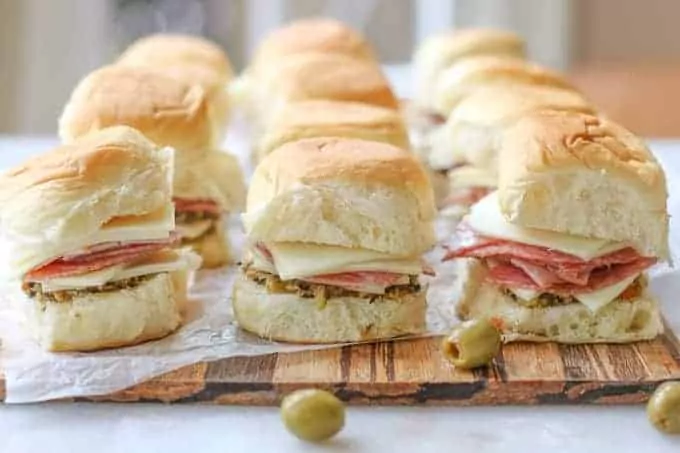 Salami, cheese and olive spread on small rolls.