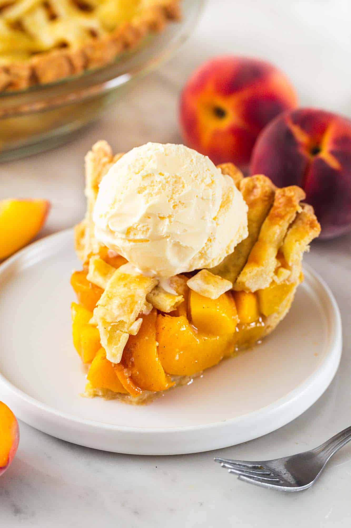 sliced peach pie with vanilla ice cream on top.