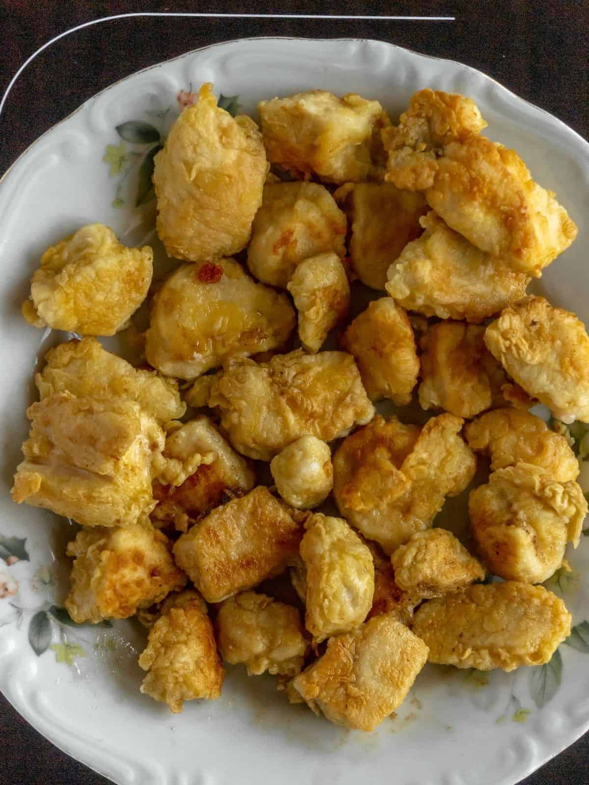 cooked breaded chicken cubes on plate.