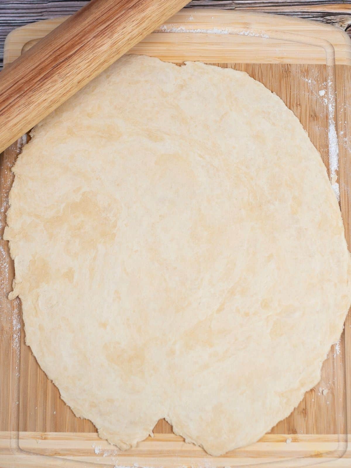 pie dough rolled out on cutting board.