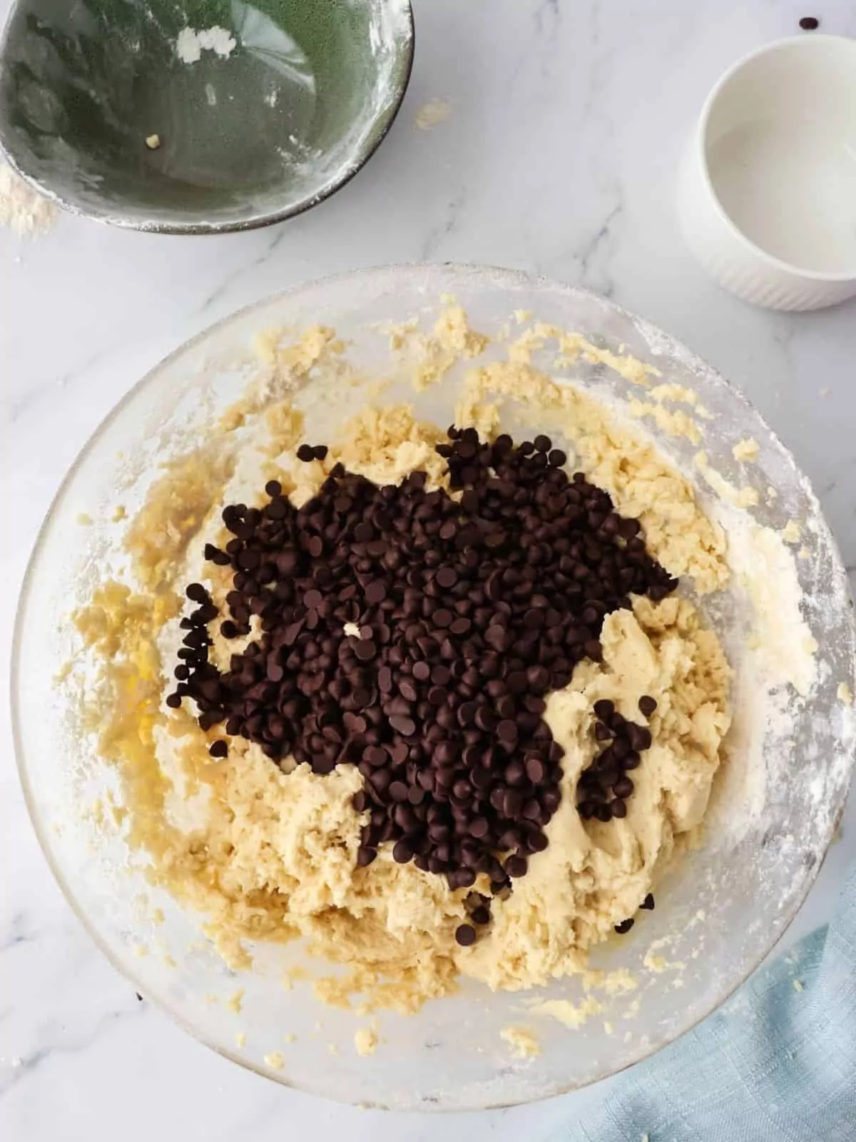 chocolate chips on top of cookie dough in bowl.