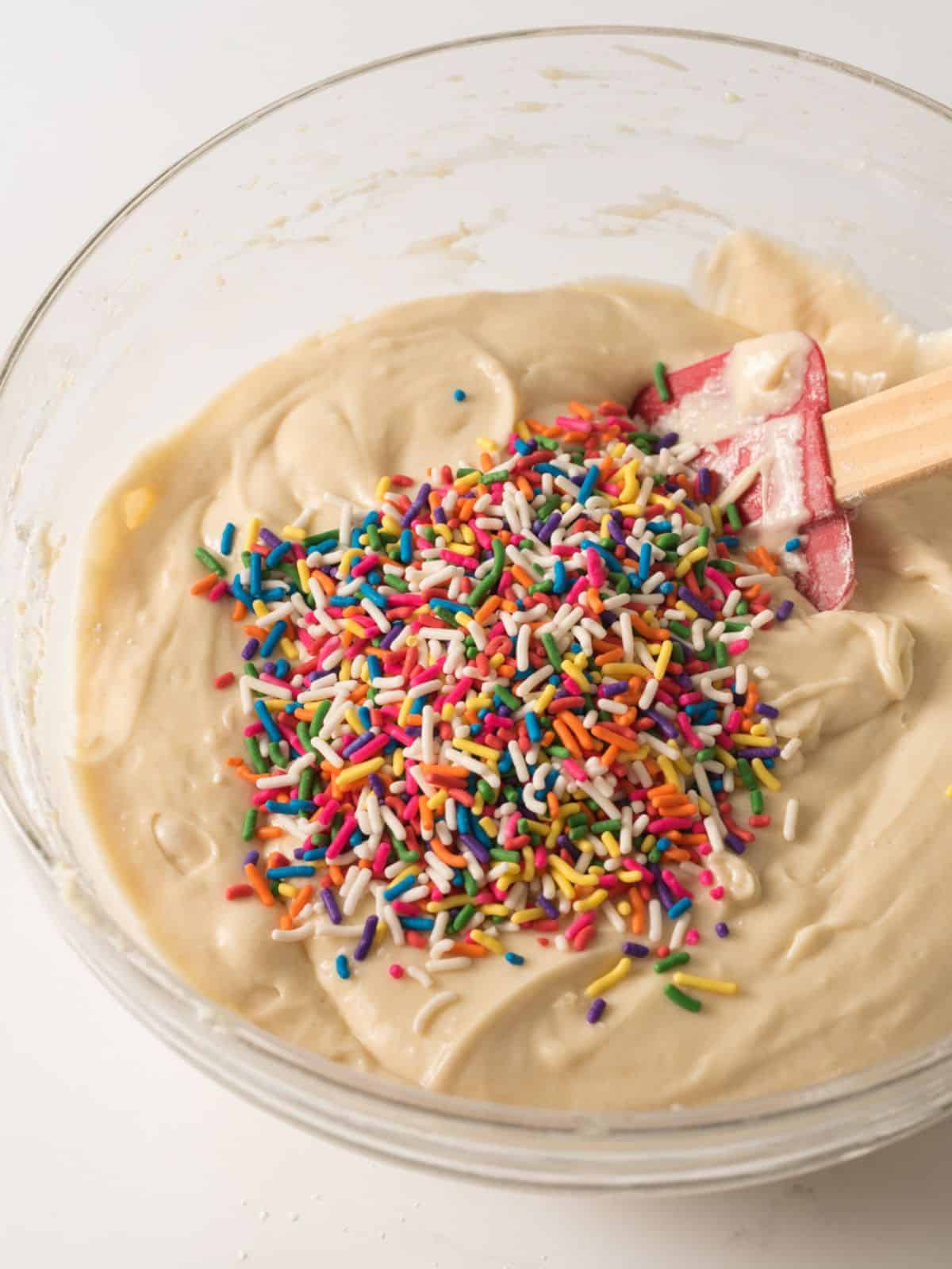 fold in rainbow sprinkles into muffin batter.
