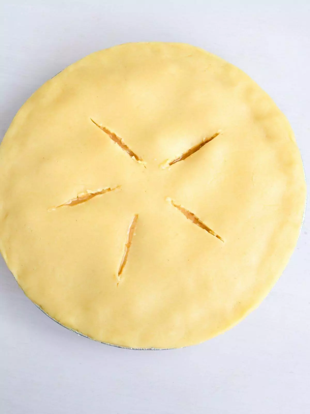 peach pie with slits cut in top pie crust.