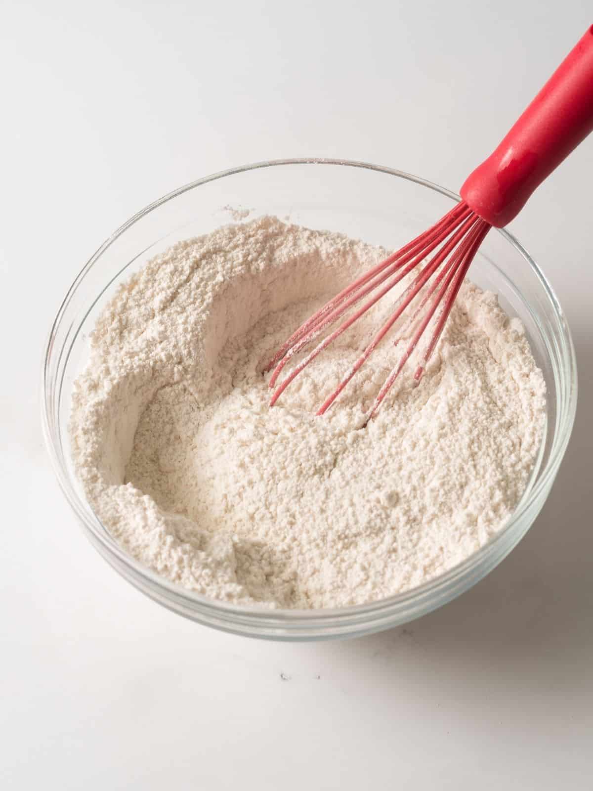 flour with wire whisk in bowl.