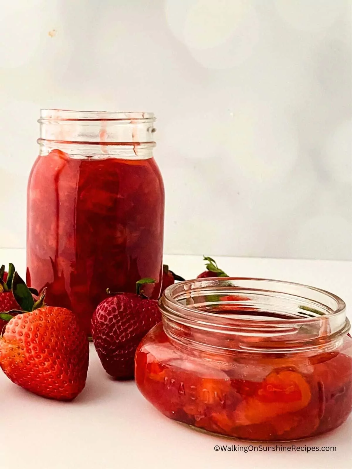 Strawberry sauce in tall mason jar and small mason jar.