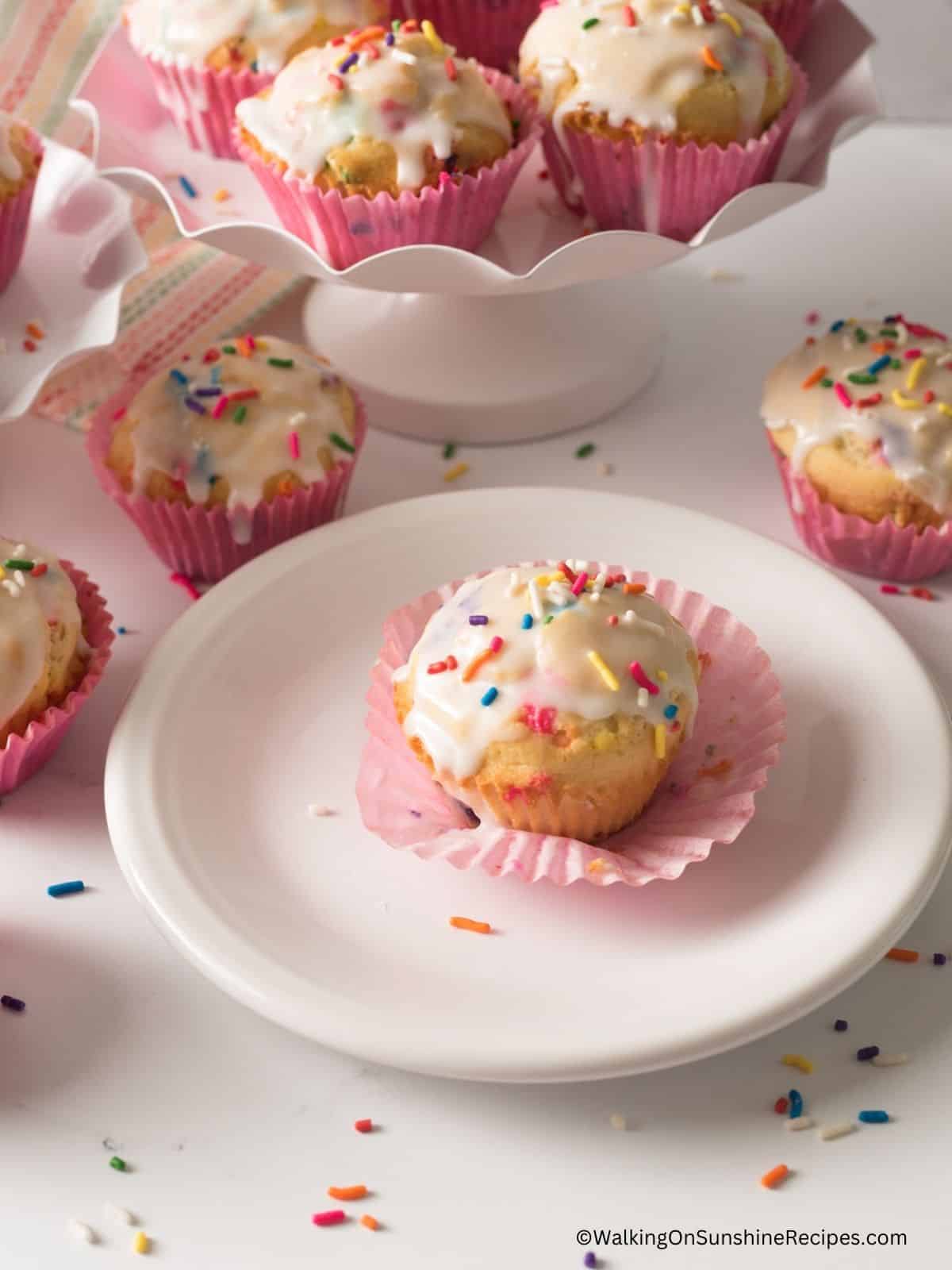 one party muffin on plate with sprinkles scattered around.