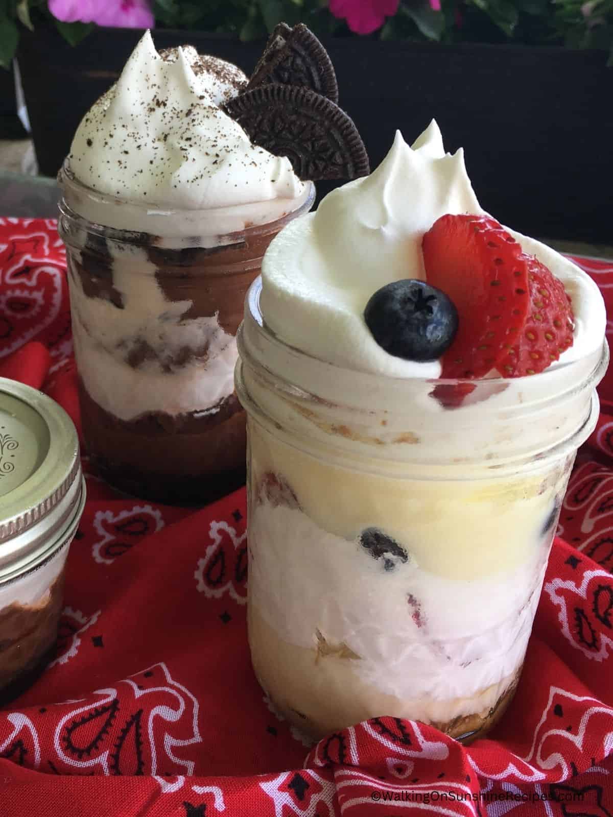 two mason jars of pudding with whipped cream.