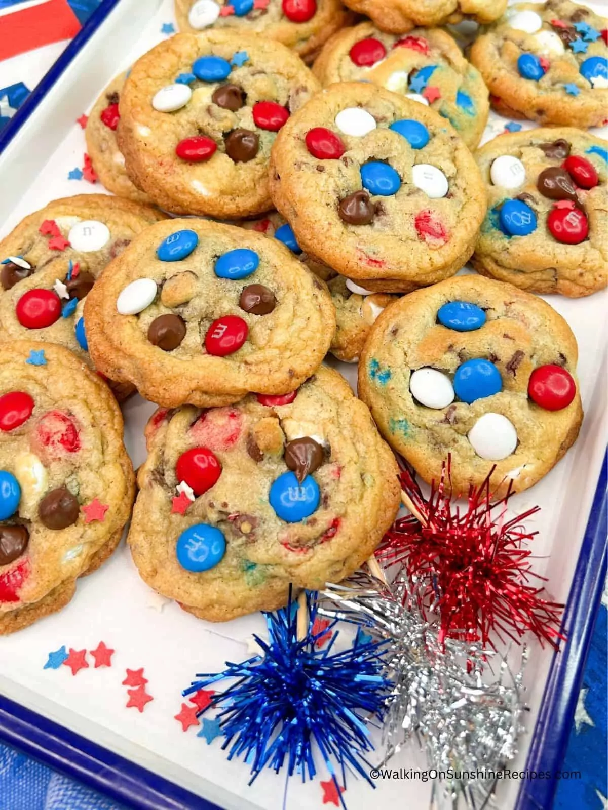 red, white and blue chocolate chip cookies on tray with flag napkins.