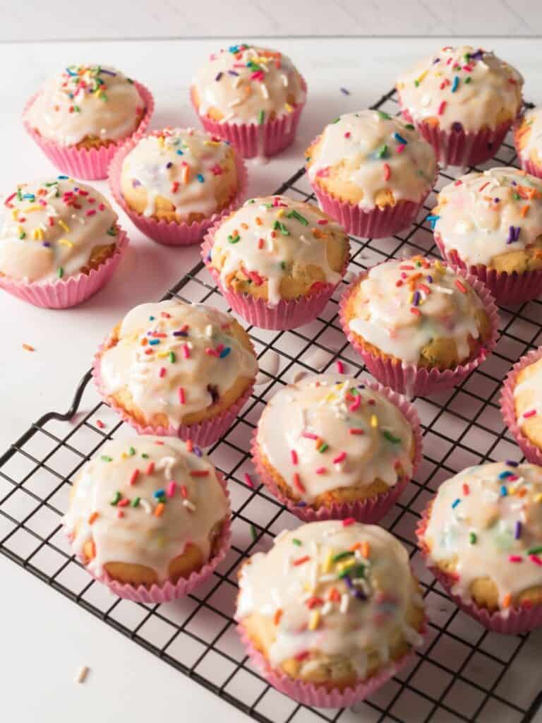 muffins in pink cupcake liners on baking rack.