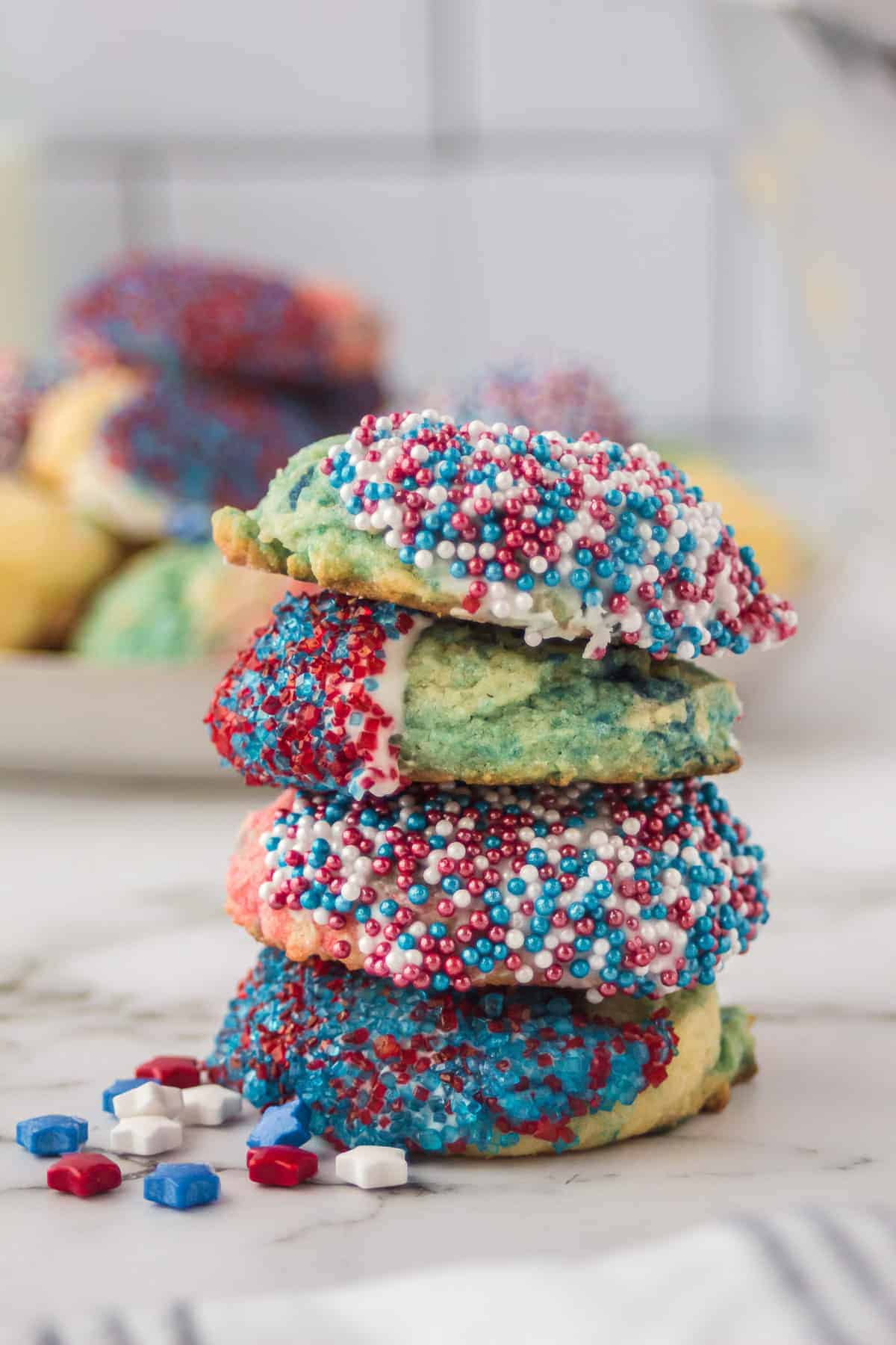 decorated sugar cookies with red, white and blue jimmies stacked.