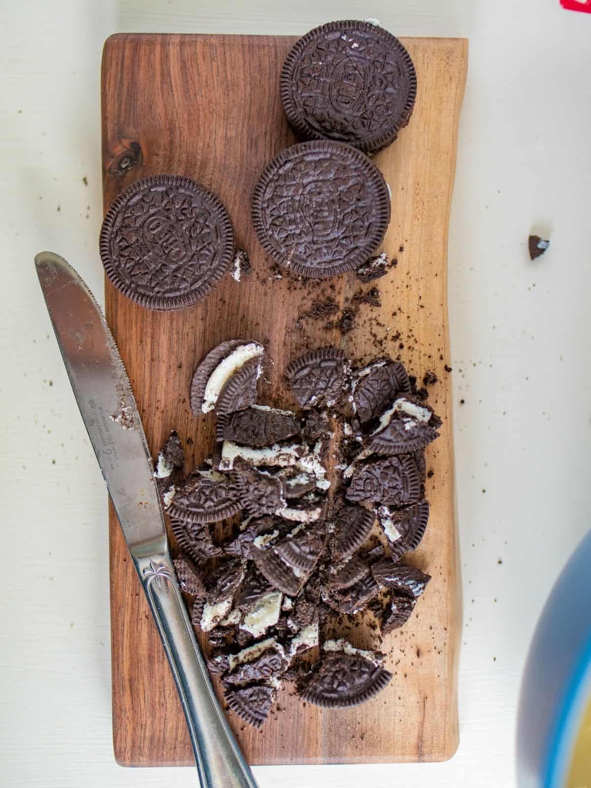 chopped and whole Oreo cookies on cutting board.