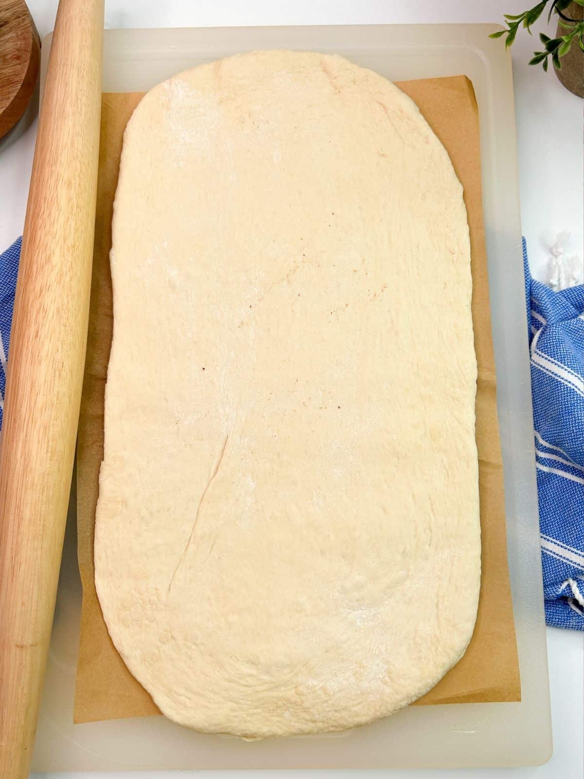 pizza dough rolled out with rolling pin.