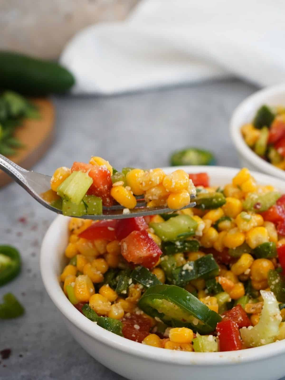 closeup of fork filled with corn salad.