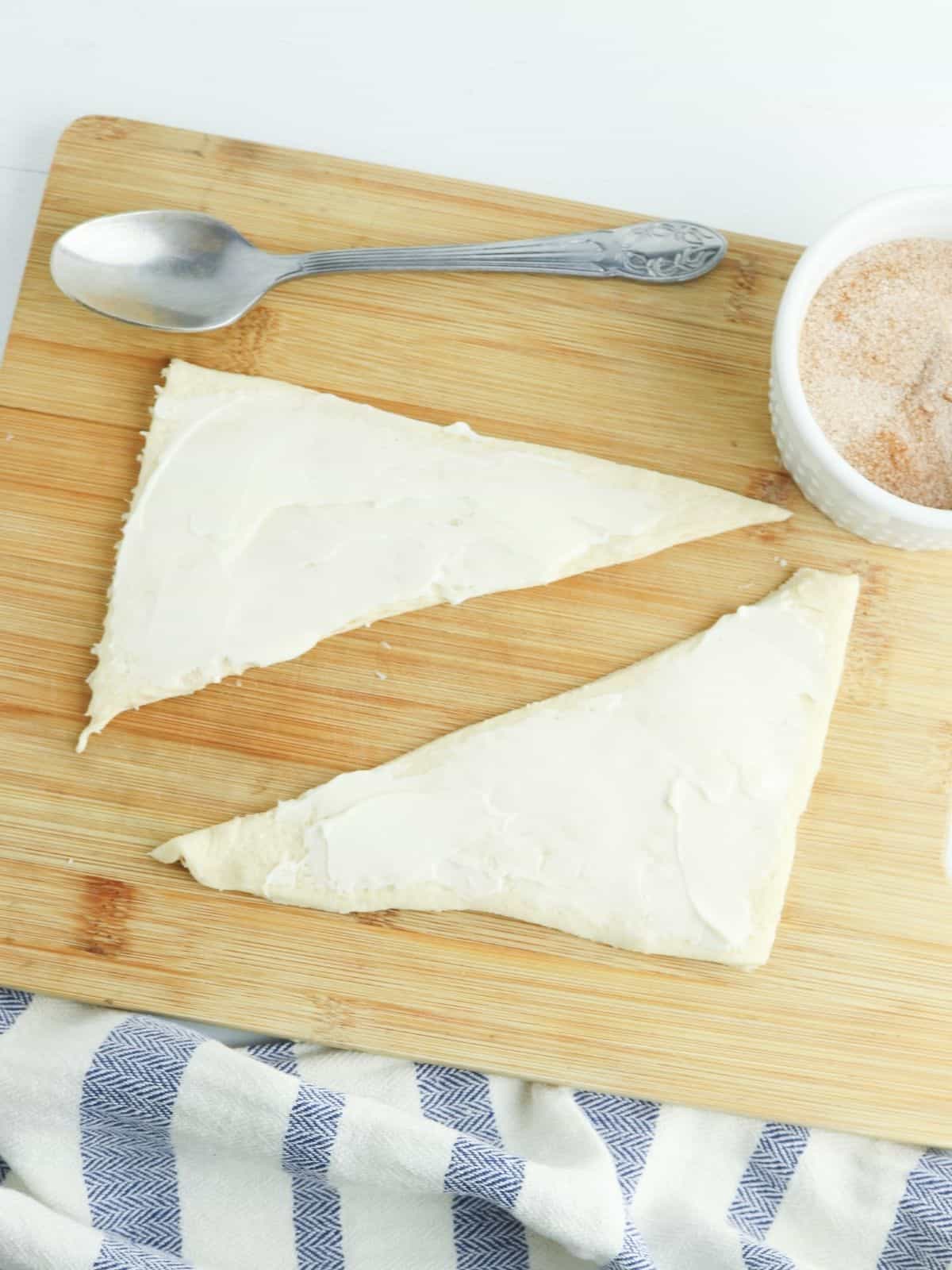 two triangle crescent rolls spread with butter.
